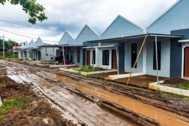 Çamurlu yolu olan bir dizi yeni yapılmış kalıcı eve benziyor..