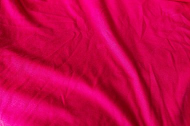 Kırmızı kumaşın dokusu kırışmış.