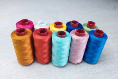 Beyaz ahşap bir masa üzerine düzgün yerleştirilmiş kumaş ipliği.