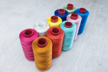 Beyaz ahşap bir masa üzerine düzgün yerleştirilmiş kumaş ipliği.