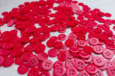 Kırmızı düğmeler kumaşın dokusuna saçılmış.