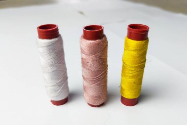 Beyaz arka planda sarı, pembe ve beyaz iplikler kullanılır.