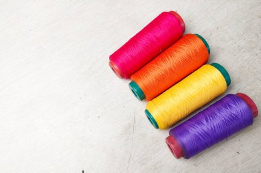 Beyaz arkaplanda sıralanmış renkli iplikler