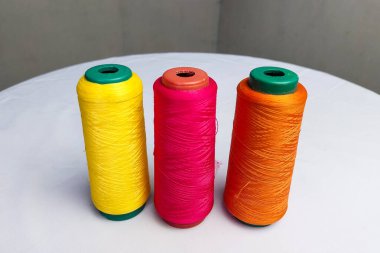 Sarı, Turuncu ve Kırmızı İplikler Beyaz Masada Duruyor