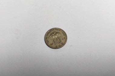 Beyaz bir arka planda Endonezya 10 rupia sikkesinin yakın plan görüntüsü. Para birimi kavramları, küçük değerler ve günlük finansal işlemler.