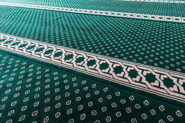 Beyaz geometrik ve çiçek motifli yeşil desenli halılara yakın çekim.