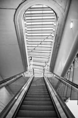 Modern bir istasyondaki bir yürüyen merdivenin siyah beyaz resmi: güzel perspektif.
