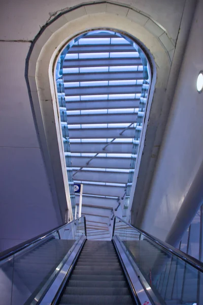 Modern binanın iç mimarisi: bir istasyondaki tırmanan bir yürüyen merdivenden alt-üst perspektif. Çağdaş mimari.