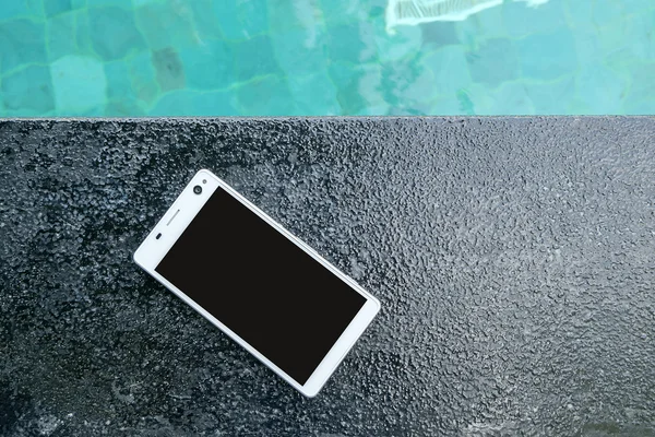 Smartphone in Schwimmbadnähe. — Stockfoto