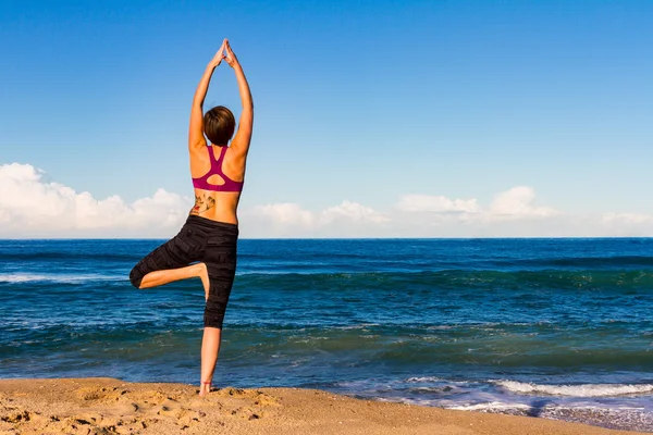 Giovane donna fa Yoga su una spiaggia Foto Stock Royalty Free