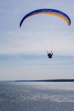 Sarı ve mavi parasail uçan adam