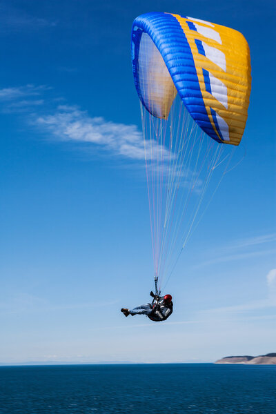 Man performing flyby with yellow and blue parasail