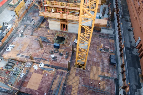 Grúa elevándose a través del piso de rascacielos en construcción — Foto de Stock