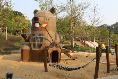 Ayı şekilli çocukların oyun parkının ilginç bir tasarımı var. Çocukların oynaması için kum ve ahşap elementler, slaytlar ve tırmanma yapıları var.