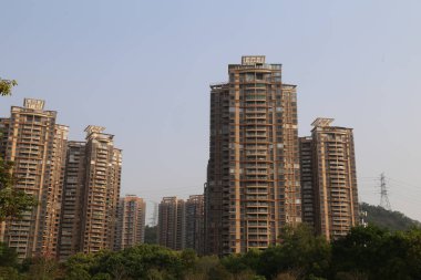 Bir sürü yüksek binası olan bir şehir silueti. En uzun bina, sağdaki bina. Gökyüzü açık ve mavi