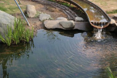 Parkta bir su ıslah sistemi var. Bir boru yukarıdan bir gölete akıyor. Nehir, ucundaki küçük kayalara bağlıdır.