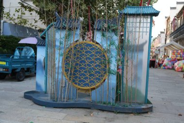 Şehir meydanında, Çinli ressamların tarzında çocuklar tarafından yapılmış bambu çit ve mavi saçaklar gibi bir enstalasyon sanatı var. Yuvarlak pencerenin üzerinde renkli cam süslemeler, boyanmış altın folyo ve kırmızı süslemeler var.
