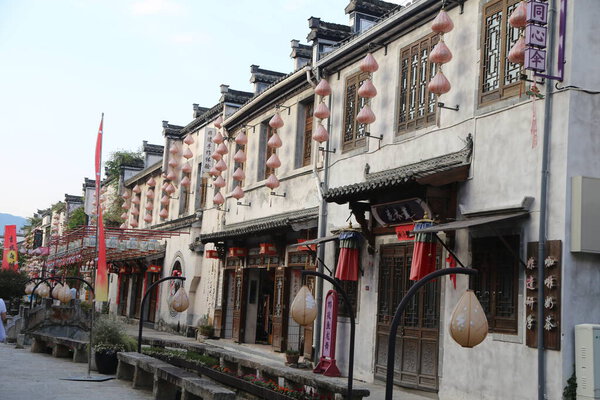 Улица со множеством зданий и много света. Много людей ходит вокруг