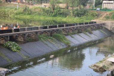 Güney Çin 'in ilkbaharında, kışın öğleyin, bir tarafında eski bir baraj ve içinden akan bir nehir vardır. Su yüzeyi güneş ışığını yansıtır ve kıyılarında yeşil otlar büyür..