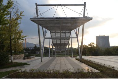Dikdörtgen metal yapı beton zeminde duruyor, üzerinde çelik örgüden yapılmış bir kubbe ve üzerinde çatısı yok..