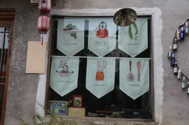 Pencerede bir sıra pankart asılıydı. Her pankartın üzerinde mutfak gereçleri ve yemek malzemelerini gösteren bir resim vardı..