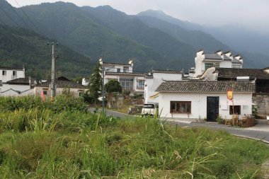 Evleri ve kilisesi olan küçük bir kasaba. Evler beyaz ve kilise kırmızı. Arka planda ağaçlar var.