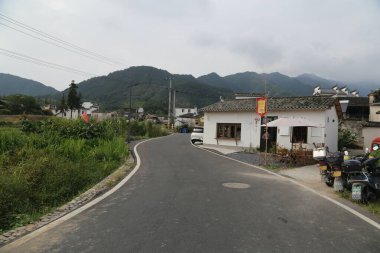 Çin 'in kırsal kesimlerinde, her iki tarafında beyaz duvarlar ve siyah fayanslar olan bir yol, geleneksel Çin tasarımı tarzında yerli halk tarafından dekore edilmiş eski bir evdir..