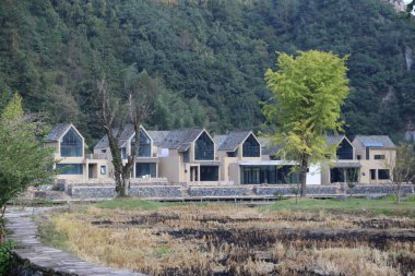 modern, küçük evlerin mimari bir dış tasarımı gable çatıları ve kırsal Çin 'deki nehir kıyısı boyunca yan cephe boyunca geniş pencereleri olan..