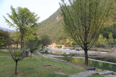 Park, dalgalı nehrin kıyısında, önünde yeşil çimenler ve ağaçlarla yer almaktadır. Nehir kıyısının dışından girişe giden eski bir yol da vardı..