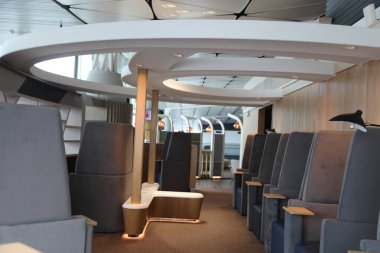 Köprüsüz yolcu feribotunun iç kısmı, her iki tarafında gri kumaş koltukları olan zarif ve basit bir tasarıma sahiptir. Tavan kenarlarında kıvrılarak oturma alanı oluşturur..