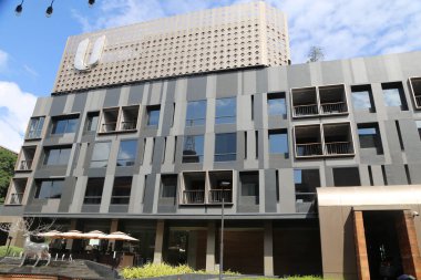 Otelin dış tarafında siyah aksanlı gri duvarlar, zarif ve modern bir görünüm yaratıyor. Bina, Chiang Mai 'nin yemyeşil manzarasını sergiliyor.