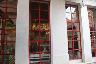 Dangurembun caddesindeki mağazanın pencere çerçeveleri kırmızı, modern tarzda cam ve beyaz sütunlarla çevrili..