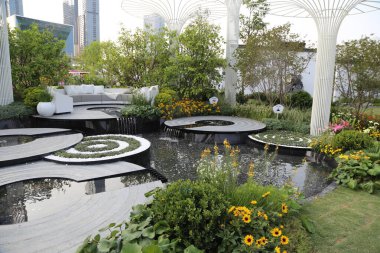 Suyun özelliklerine sahip bir çatı bahçesi, oturma ve süs bitkileri Çin 'in yeni yılında gün boyunca sallanıyor, beyaz çelik kolonları olan gökdelenlerle çevrili..