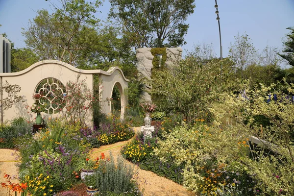 Ev ve bahçe fuarındaki sergi bahçesinde çeşitli çiçeklerle çevrili bir kemer yolu bulunuyor. Peyzaj tasarımı çevresindeki küçük yeşillikleri içerir ve doğal bir atmosfer yaratır..