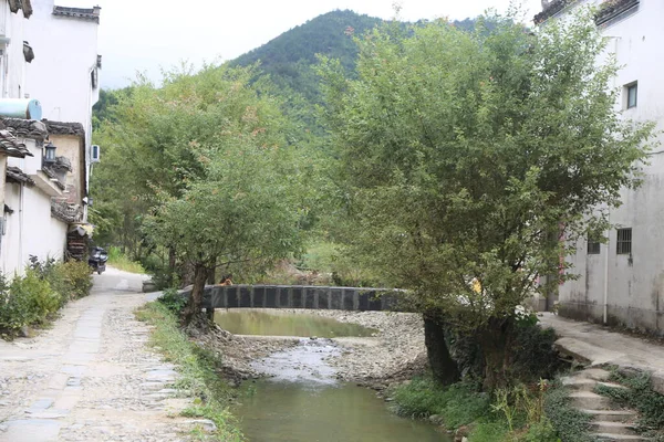 Köydeki akarsu, her iki tarafında beyaz duvarlar ve siyah fayanslar olan söğüt ağaçlarıyla çevrilidir. Yüzeyinin üzerinde eski bir taş köprü var..