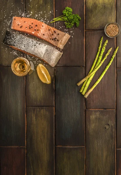 Somon, limon, kişniş ve ahşap bir masa üzerinde kuşkonmaz. Metin için yer