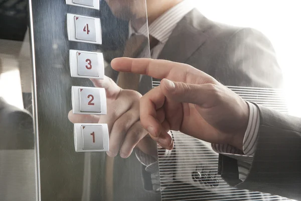 El asansör düğmesine basar