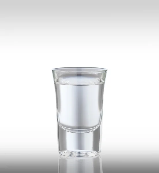 Un vaso de vodka sobre un fondo claro . — Foto de Stock