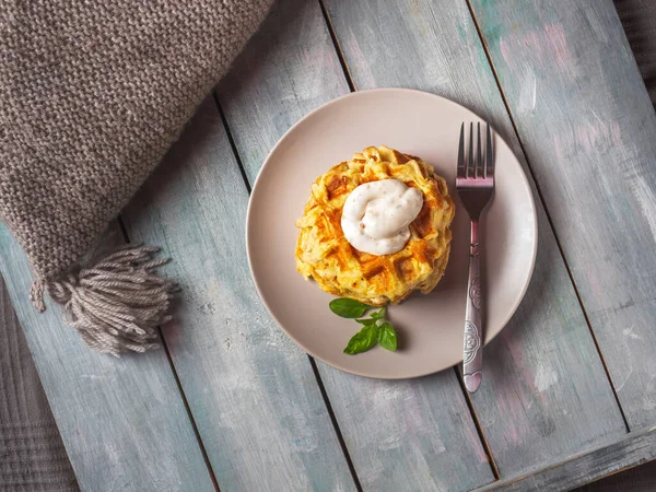 Placa redonda de cerâmica com waffles de abobrinha com molho de queijo e manjericão em bandeja de madeira Imagens De Bancos De Imagens Sem Royalties