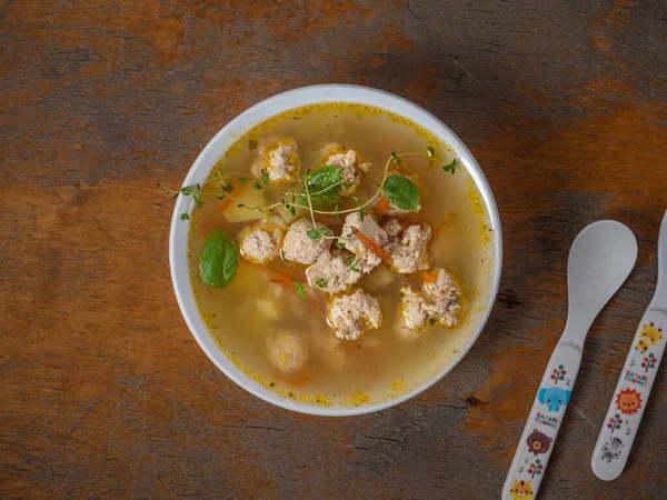 Porção de crianças de sopa com almôndegas de frango em um prato branco profundo Fotos De Bancos De Imagens