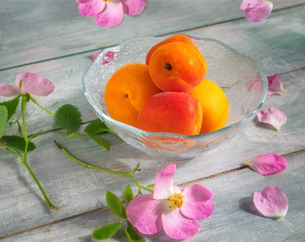 Ripe Apricots Glass Vase Pink Rosehip Flowers Blue Wooden Table — Stock Photo, Image