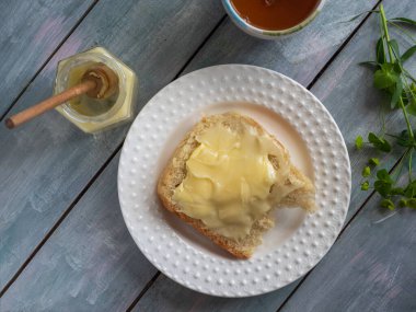 Kepek ekmeğinde ballı sandviç ve ballı irmik ve bal kaşıklı üst manzara.