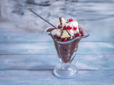 Krem şantili ekmek çorbası, kırmızı frenk üzümü ve uzun cam bir kâsede çikolata.