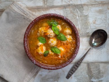 Havuçlu ve kabaklı sebze çorbası, ahşap bir masada derin bir tabakta tavuk köftesi.