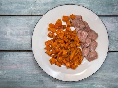 Ekşi krema ve sarımsak soslu kızarmış balkabağı ve beyaz tabakta haşlanmış hindi etiyle kahvaltı.