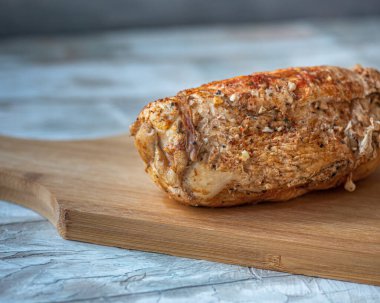 Mutfak tahtasındaki tavuk jambonu hazır, ahşap mavi tepside duruyor. Yaklaş.