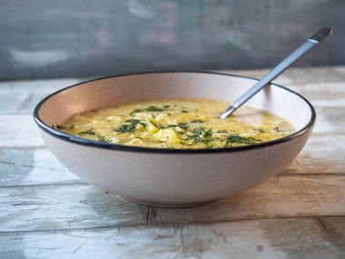 Öğle yemeğinde köfteli çorba ve hafif seramik tabakta dereotu yakın plan bir masada.