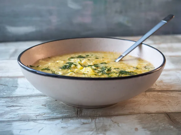 Öğle yemeğinde köfteli çorba ve hafif seramik tabakta dereotu yakın plan bir masada.