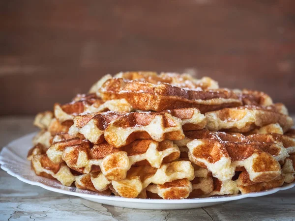 Beyaz bir tabakta bir yığın waffle Işık masasında yakın plan