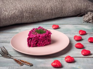 Valentines day greetings breakfast, serving beet salad on a wooden tray standing on the sofa